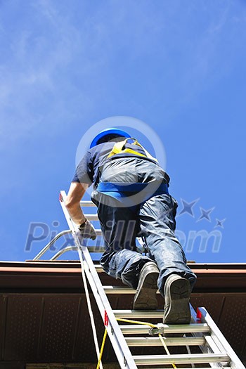 Construction worker climbing extension ladder to roof Construction worker climbing extension ladder to roof