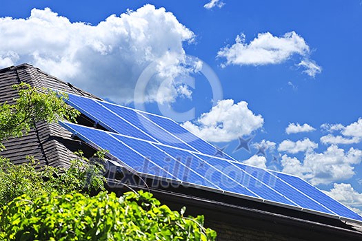 Array of alternative energy photovoltaic solar panels on roof of residential house Array of alternative energy photovoltaic solar panels on roof of residential house