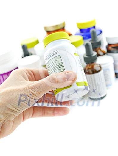 Hand holding medicine bottle to read label Hand holding medicine bottle to read label