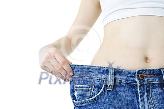 Fit young woman in loose jeans after losing weight isolated on white Fit young woman in loose jeans after losing weight isolated on white