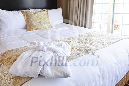 Comfortable bed with clean bathrobe in upscale hotel Comfortable bed with clean bathrobe in upscale hotel
