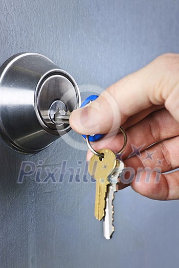 Hand inserting keys in door lock close up Hand inserting keys in door lock close up