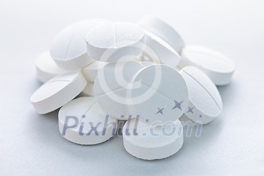 Calcium supplement pills in a pile closeup Calcium supplement pills in a pile closeup