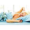 Woman waking up stretching in bed with morning sunshine