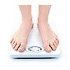 Bare female feet standing on bathroom scale