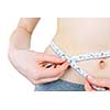 Fit young woman measuring waist with tape