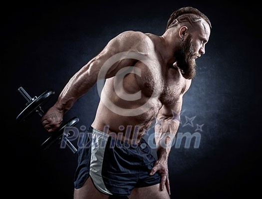 Strong bodybuilder with six pack, perfect abs, shoulders, biceps, triceps and chest. Power athletic bearded man in training pumping up muscles with dumbbell. Strong bodybuilder with six pack, perfect abs, shoulders, biceps, triceps and chest. Power athletic bearded man in training pumping up muscles with dumbbell.