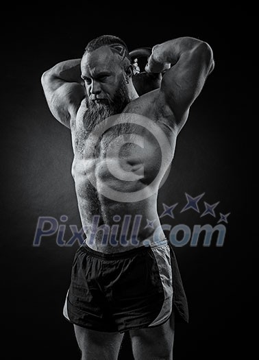 Bodybuilder with a beard lifts a heavy kettlebell. Black and white portrait of a strongman. Bodybuilder with a beard lifts a heavy kettlebell. Black and white portrait of a strongman.