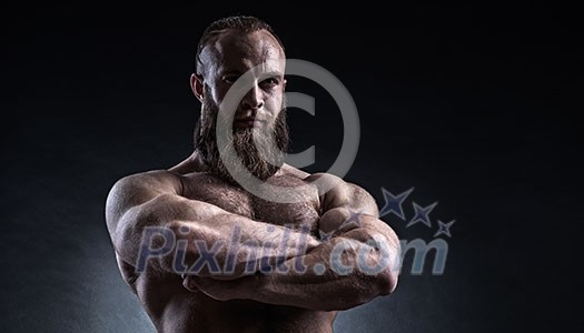 Strong bearded man with perfect abs, shoulders, biceps, triceps and chest. Bodybuilder topless over black background. Strong bearded man with perfect abs, shoulders, biceps, triceps and chest. Bodybuilder topless over black background.