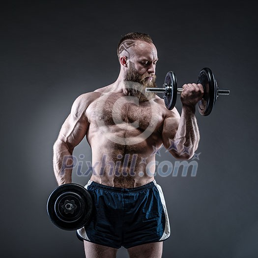 Power athletic bearded man in training pumping up muscles with dumbbell. Strong bodybuilder with six pack, perfect abs, shoulders, biceps, triceps and chest. Power athletic bearded man in training pumping up muscles with dumbbell. Strong bodybuilder with six pack, perfect abs, shoulders, biceps, triceps and chest.