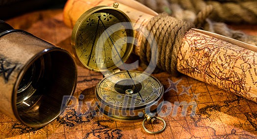 Old vintage retro compass and spyglass on ancient world map. Vintage still life. Travel geography navigation concept background.