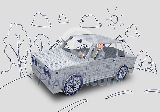 Young man driving car made of sheet of paper Young man driving car made of sheet of paper
