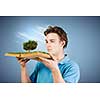 Young man in casual holding opened book with green tree