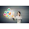 Young attractive businesswoman touching media colorful icon