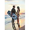 romantic couple in surf wear posing at beach on sunset at summer season