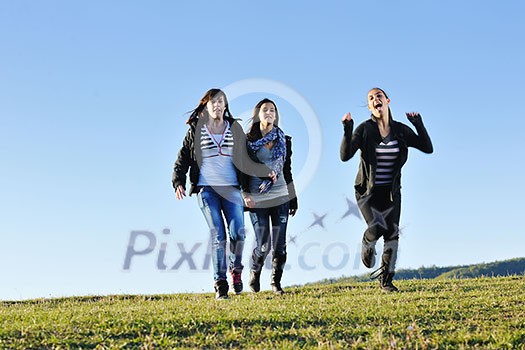 group of teen people woman have fun outdoor with blue sky in background group of teen people woman have fun outdoor with blue sky in background