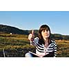 young teen girl read book and study homework outdoor in nature with blue sky in background