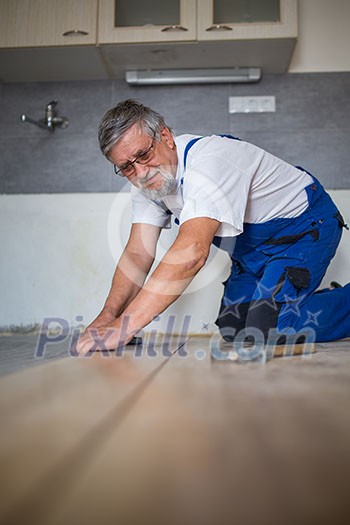 DIY, repair, building and home concept - close up of male hands lying parquet floor board/laminate flooring (shallow DOF; color toned image) DIY, repair, building and home concept - close up of male hands lying parquet floor board/laminate flooring (shallow DOF; color toned image)