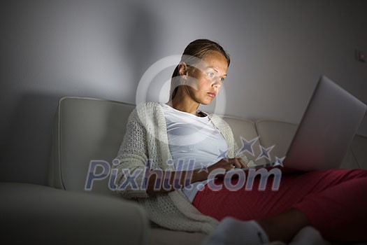 Very tired young woman, burning the midnigh oil - working late at night on her laptop computer, at home, sitting on sofa, rubbing her tired eyes, trying to stay focused Very tired young woman, burning the midnigh oil - working late at night on her laptop computer, at home, sitting on sofa, rubbing her tired eyes, trying to stay focused