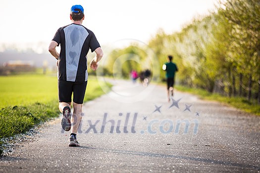 Male athlete/runner running on road - jog workout well-being concept Male athlete/runner running on road - jog workout well-being concept