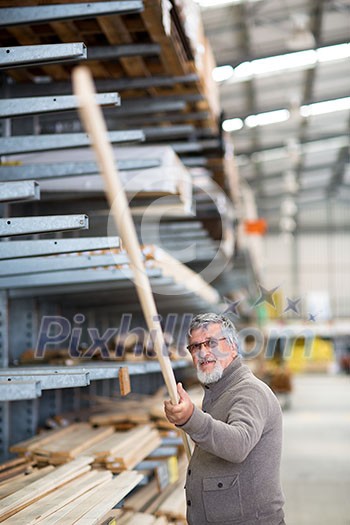 Man choosing and buying construction wood in a DIY store for his DIY home re-modeling project Man choosing and buying construction wood in a DIY store for his DIY home re-modeling project
