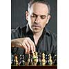 Man moving a chess pawn on wooden chessboard as first move