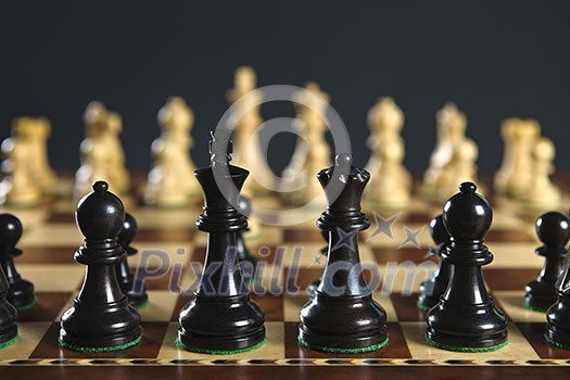 Close up of chess pieces on wooden chessboard Close up of chess pieces on wooden chessboard