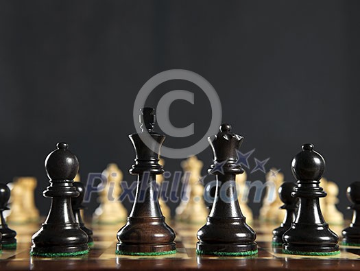 Close up of chess pieces on wooden chessboard Close up of chess pieces on wooden chessboard