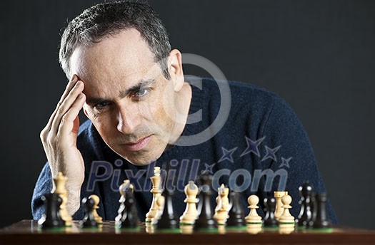 Chessboard with man thinking about chess strategy Chessboard with man thinking about chess strategy