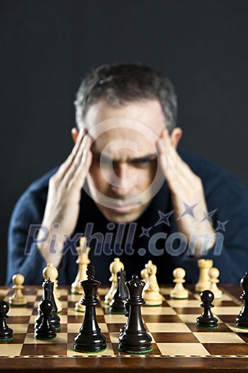 Chessboard with man thinking about chess strategy Chessboard with man thinking about chess strategy