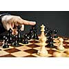 Finger pushing over King chess piece in defeat