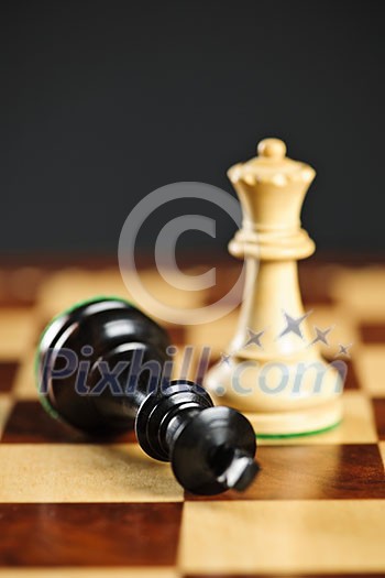 Closeup of checkmate on king by queen winning in chess game Closeup of checkmate on king by queen winning in chess game