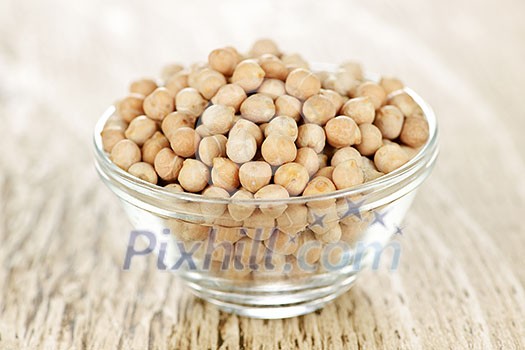Dry raw organic chickpeas in small glass bowl