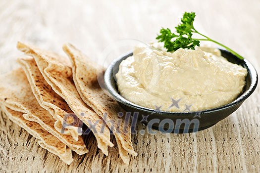 Bowl of fresh hummus dip with pita bread slices Bowl of fresh hummus dip with pita bread slices