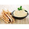Bowl of fresh hummus dip with pita bread slices