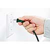 Hand inserting green electrical plug into outlet