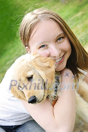 Portrait of smiling teenage girl holding golden retriever puppy Portrait of smiling teenage girl holding golden retriever puppy