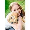 Portrait of smiling teenage girl holding golden retriever puppy