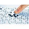 Finger pushing missing puzzle piece into place