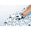 Finger pushing missing puzzle piece into place