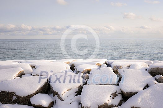Rocks under snow on winter shore of lake Ontario in Sylvan park Toronto Rocks under snow on winter shore of lake Ontario in Sylvan park Toronto