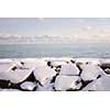 Rocks under snow on winter shore of lake Ontario in Sylvan park Toronto