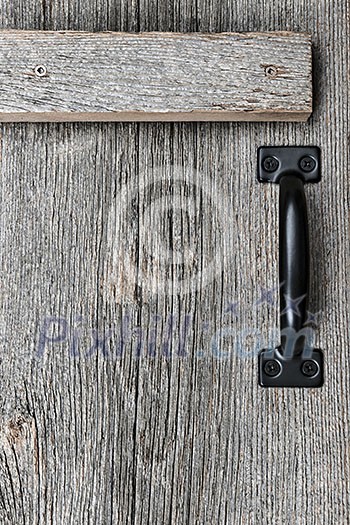 Distressed rustic barn wood door with handle as textured background Distressed rustic barn wood door with handle as textured background
