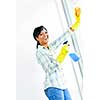 Smiling black woman cleaning windows with glass cleaner