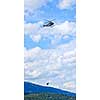 Rescue helicopter rescuing person by airlifting dangling on rope in Alberta Canada