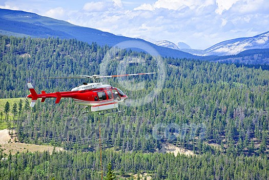 Red rescue helicopter flying emergency mission in mountains, Alberta Canada Red rescue helicopter flying emergency mission in mountains, Alberta Canada
