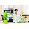 Smiling young black woman with sponge and rubber gloves cleaning kitchen
