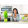Thoughtful black woman holding coffee mug in modern kitchen interior