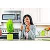 Smiling black woman holding coffee mug in modern kitchen interior