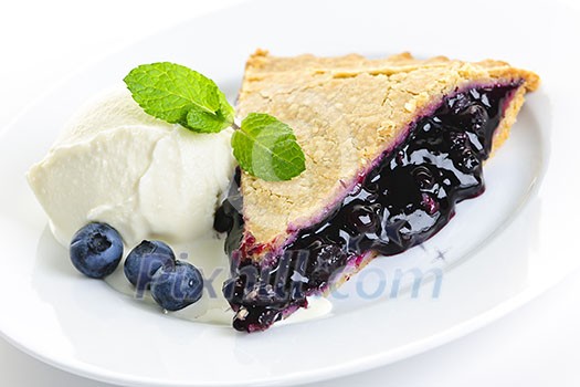 Slice of blueberry pie with vanilla ice cream and berries Slice of blueberry pie with vanilla ice cream and berries
